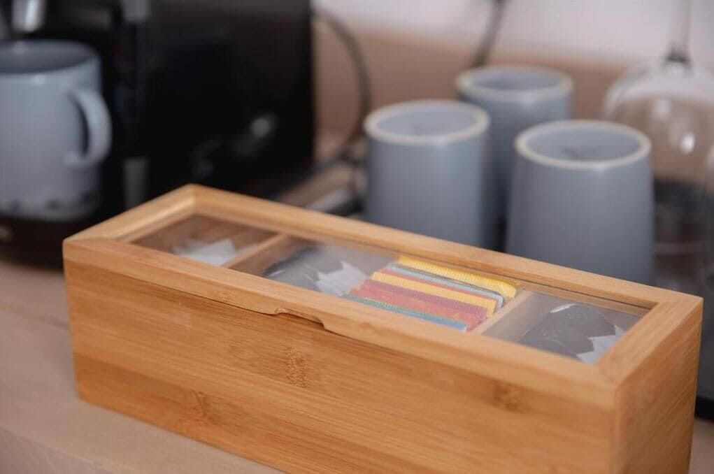 Una scatola di legno con un vetro frontale, che contiene oggetti colorati.