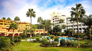 Ein Resort mit mehreren Gebäuden, einem Pool und üppiger Bepflanzung.
