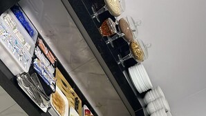A buffet setup with various food items and condiments. - Hotel Ellos (Itaquaquecetuba)