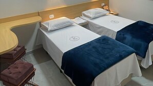 A hotel room with two beds, a small table, and a chair. - Hotel Ellos (Itaquaquecetuba)