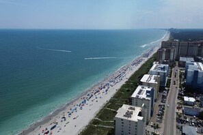 An aerial view of a beach with buildings adjacent to it.