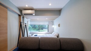 A narrow room with a bed, a window, and a hanging light fixture. - Akasaka Roppongi area with elevator Quiet high-class residential apartment close to train station (港区)