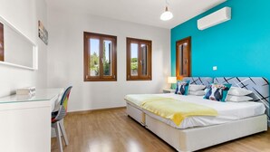Un dormitorio con una cama, un escritorio y dos ventanas.