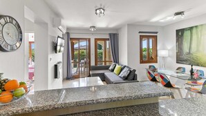Una sala de estar moderna con un sofá, una mesa de comedor y un cuadro grande.