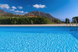 En kristallklar pool med ett berg i bakgrunden.