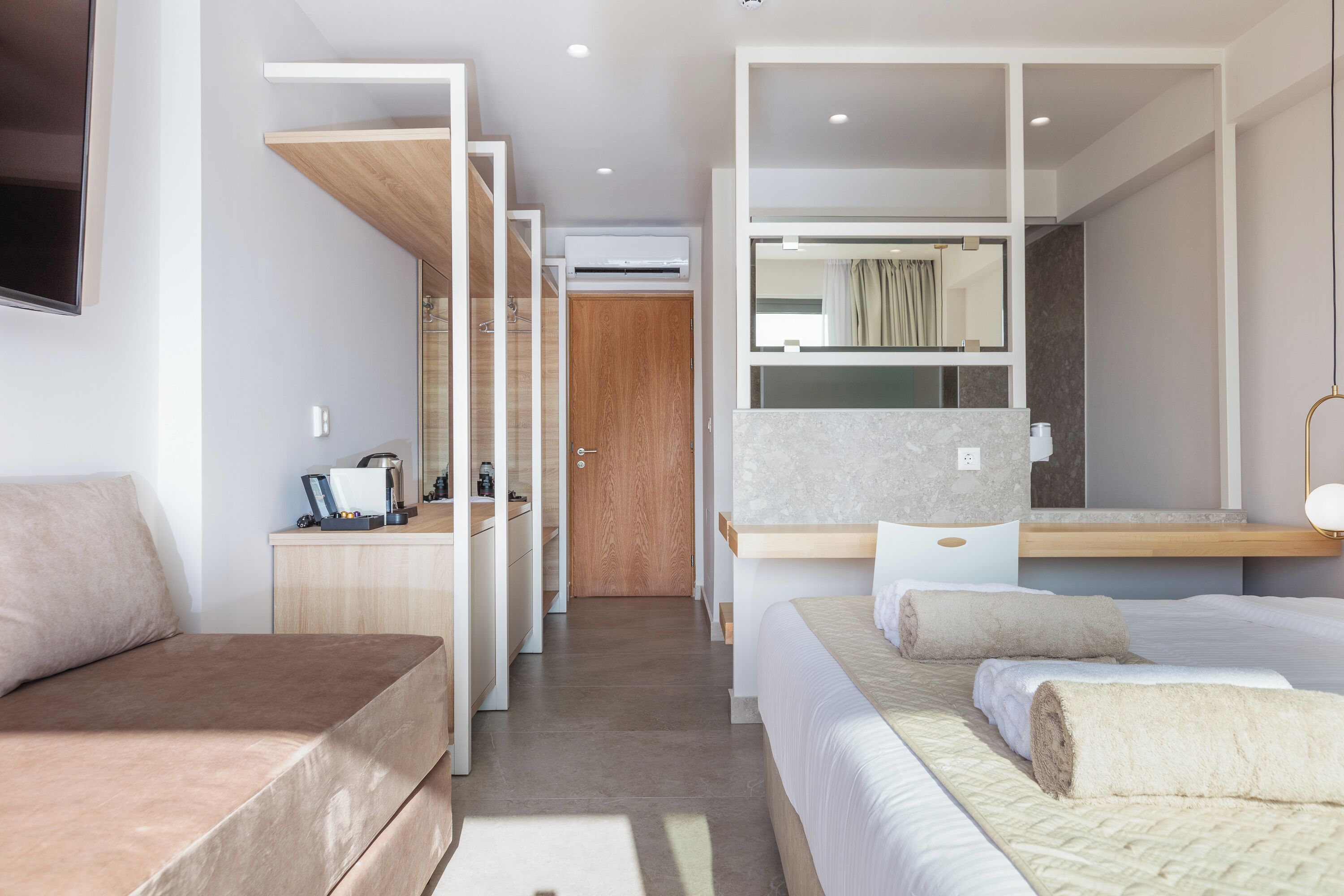 Une chambre d’hôtel moderne équipée d’un lit, d’un bureau, d’une armoire et d’une salle de bain.