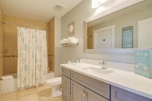 Une salle de bain avec douche, toilettes et lavabo.