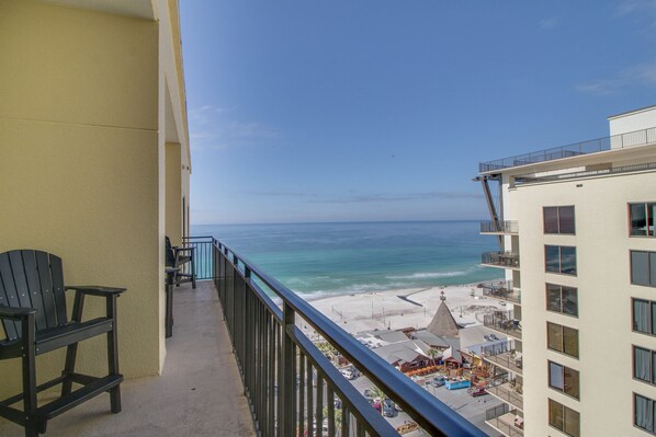 Un balcon avec vue sur la plage et l’océan.