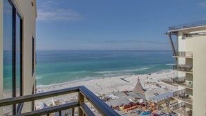 Een hoog hotel met uitzicht op een strand en de oceaan.