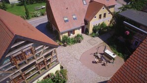 Un edificio residencial con patio, una zona de estar al aire libre cubierta y una estructura de varios pisos con balcones.