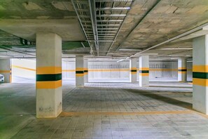 Eine leere Tiefgarage mit Betonpfeilern und gefliestem Boden.