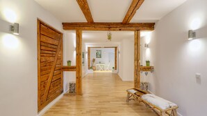 A hallway with wooden beams, a bench, and wall-mounted lights. - Bunter Bock  Die Harz-Urlaubs-Alm (Clausthal-Zellerfeld)
