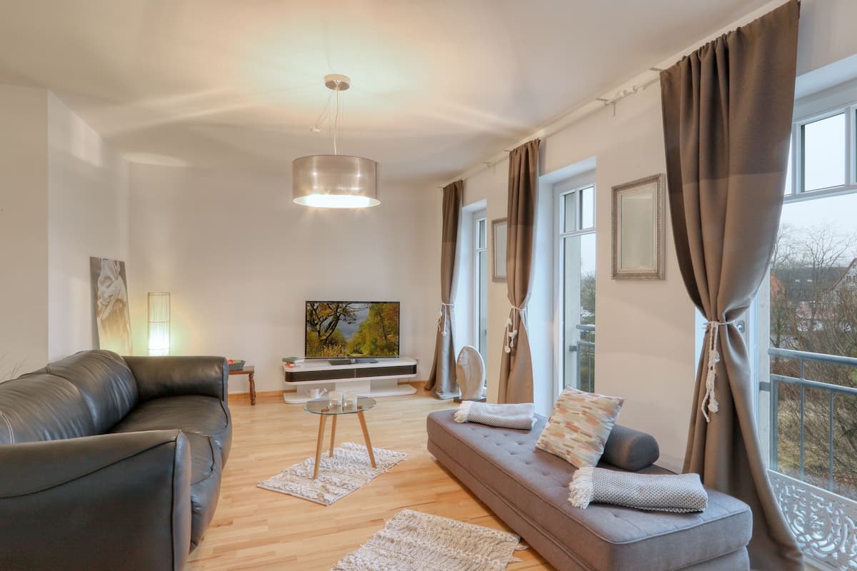 A modern living room with a sofa, a coffee table, and a TV.