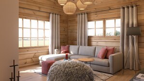 A cozy cabin interior with a wooden ceiling, a grey sofa with red cushions, a round furry ottoman, and a floor lamp. - Bunter Bock  Die Harz-Urlaubs-Alm (Clausthal-Zellerfeld)