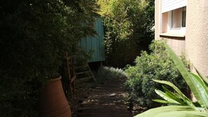 Un sendero de madera que conduce a un edificio con una ventana.