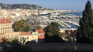 Una marina con numerose imbarcazioni ormeggiate, circondata da edifici e con una vista aperta sul mare.