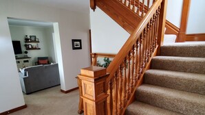 A staircase with wooden balusters and carpeted steps leading to an upper floor. - Charming Nauvoo Farmhouse - 1 mile from Nauvoo Temple (Nauvoo)