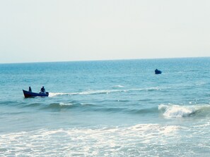 A calm sea with a small boat and a distant buoy. - Manzili SurfHouse (Aourir)