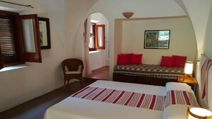 Un dormitorio con una cama grande, una silla, un escritorio y un cuadro en la pared.