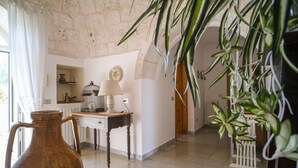 A room with a stone wall, a wooden desk, a white lamp, and a large vase. - Wonderful Trulli building in Locorotondo countryside (Locorotondo)