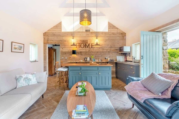Open plan seating and kitchen area. Stable doors and patio door provide plenty of light and access to the surrounding gardens.