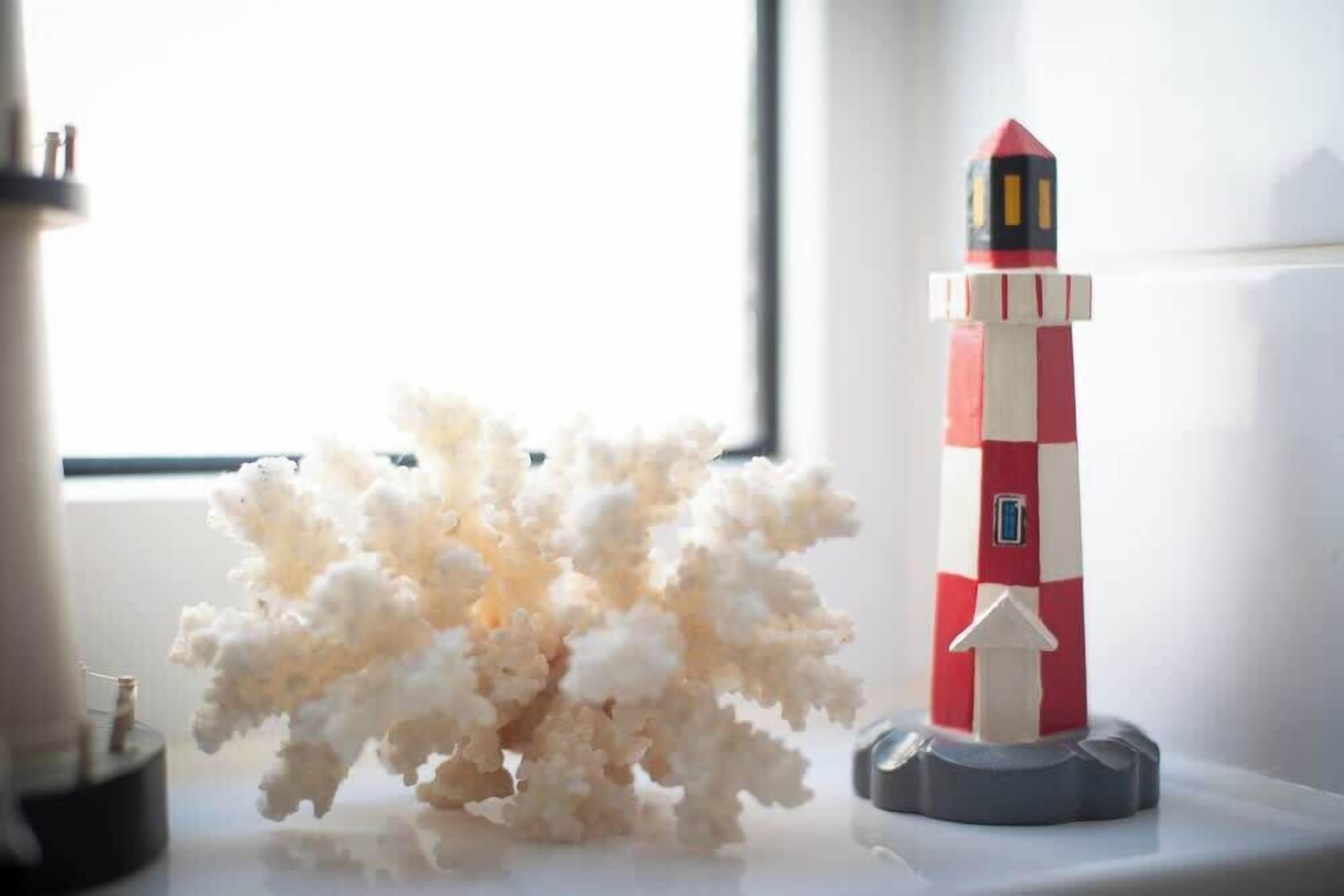 Un modellino di faro su uno scaffale accanto a una scultura di popcorn.