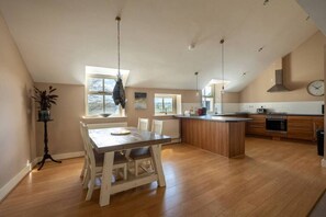 Enjoy meals in the spacious kitchen with a central island, dining area, and large window offering a view of the outdoors.