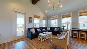 A living room with a sofa set, a coffee table, and a chandelier.