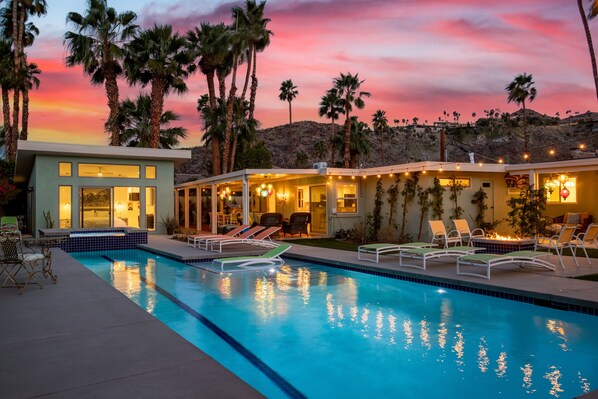A modern pool area with lounge chairs and a sunset view. - Araby Nights 4BR/4Bath Luxury Resort Home (Palm Springs)