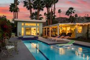 A modern house with a swimming pool, outdoor seating, and palm trees. - Araby Nights 4BR/4Bath Luxury Resort Home (Palm Springs)