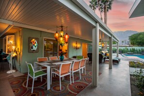 An outdoor patio with a dining area, pool, and mountain view. - Araby Nights 4BR/4Bath Luxury Resort Home (Palm Springs)