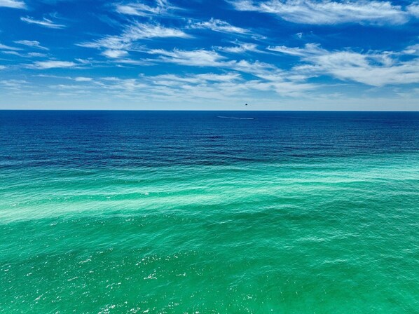 A clear view of the ocean with a boat in the distance.