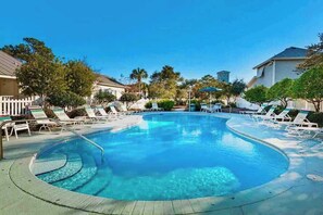 A swimming pool with lounge chairs and a fence, surrounded by trees and houses. - Tangerine Cove-5 Min 2 Beach-Golf Cart Deals (Destin)