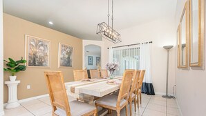 Zona pranzo con un tavolo rettangolare, sei sedie e un lampadario.