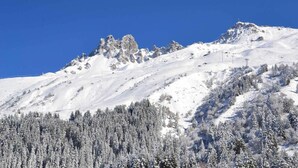 Een berg bedekt met sneeuw, met een helderblauwe lucht.