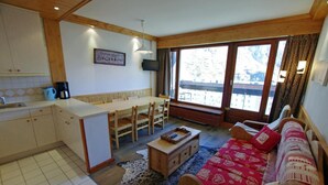 A cozy living room with a sofa, a coffee table, and a dining area with a table and chairs.