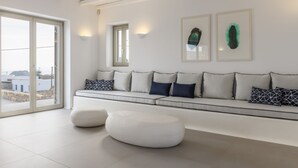 Ein modernes Wohnzimmer mit einem weißen Sofa, zwei Wandleuchten und einem großen Fenster.