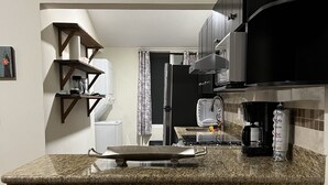 A modern kitchen with granite countertops, stainless steel appliances, and pendant lighting. - Newly renovated centrally located apartment in La Crucecita Huatulco Oaxaca  (La Crucecita)