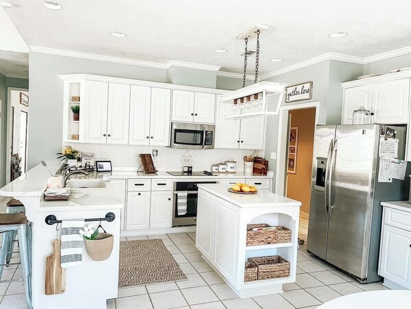 Enjoy cooking in this well-equipped kitchen with a central island, sink, and microwave.