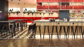 A bar area with red seating, a check-in sign, and a no smoking sign.