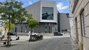 Ein modernes Gebäude mit großer Glasfassade und einem Parkplatz mit Fahrrädern.
