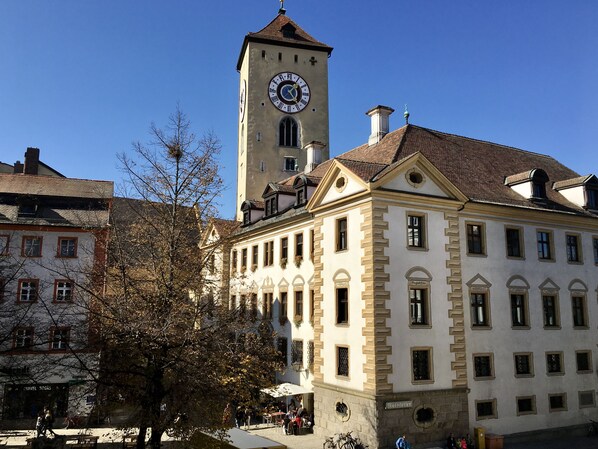 Un edificio histórico con una torre del reloj, ventanas amplias y un letrero que dice