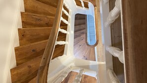 Eine Holztreppe mit weißen Geländern und einer weißen Wand.