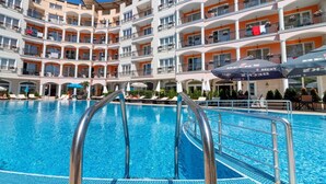 A multi-story hotel with a swimming pool, outdoor seating, and a fitness center. - Avenue Deluxe (Sunny Beach)