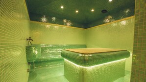 A green-tiled room with a central rectangular bathtub, a shower area, and a ceiling with recessed lighting. - Avenue Deluxe (Sunny Beach)