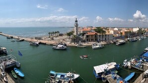 A coastal town with a harbor, boats, and a lighthouse.