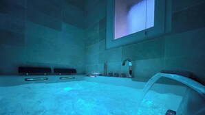 A modern bathroom with a large bathtub, a window, and a wall-mounted sink. - La Vedrenne: Smart Barn near Limoges (Bonnac-la-Côte)