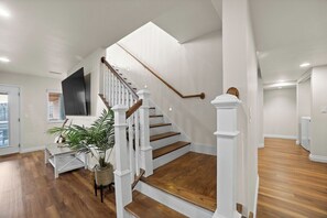 Un escalier avec des rampes blanches et des marches en bois menant à un palier.