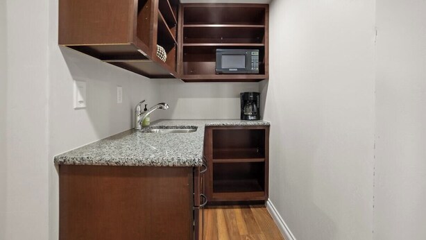 A compact kitchen with a granite countertop, a built-in microwave, and a coffee maker. - The Cliff Dweller - 3400sf, 50-Mile Views, Hot Tub (Page)