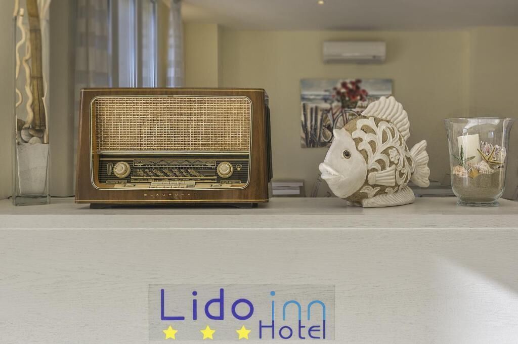 Une vieille radio, un poisson décoratif et un chandelier sur une table.